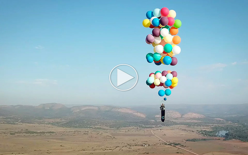 Fyr flyver tværs over Sydafrika i en stol forsynet med 100 heliumballoner