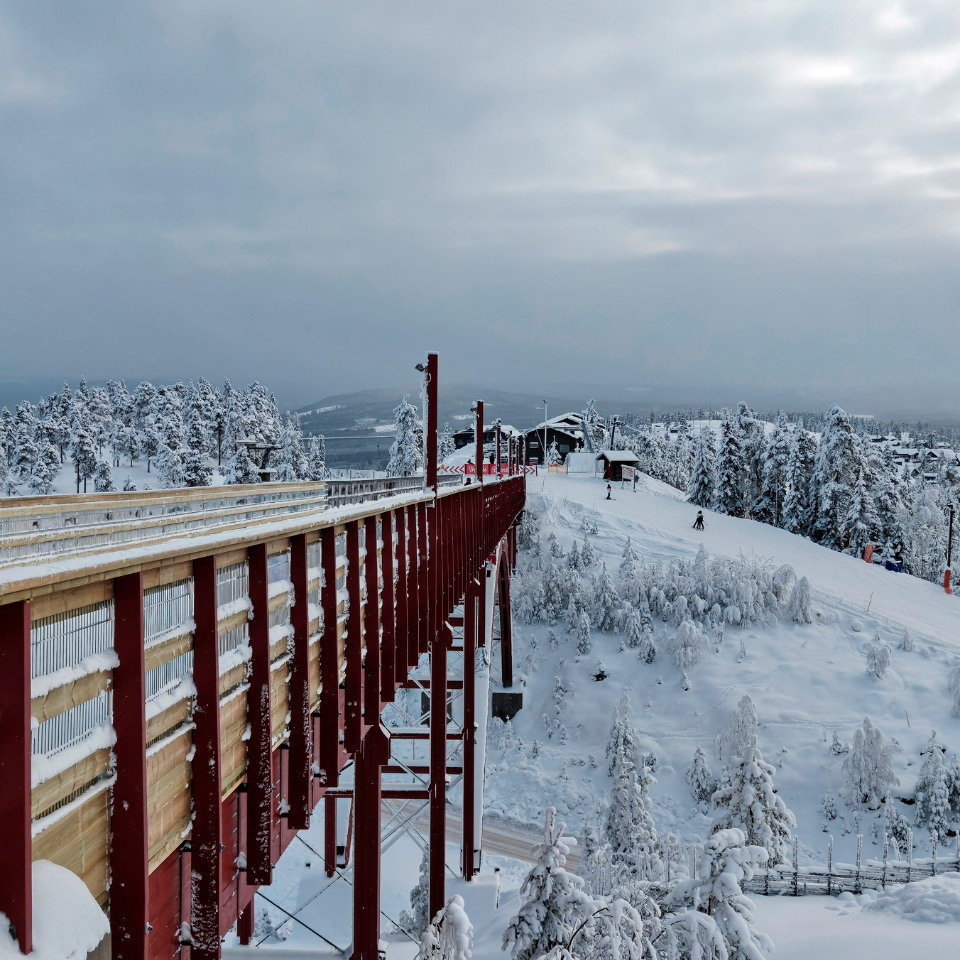 En trækonstruktion eller bro midt i skiområdet i Branäs med udsigt til faciliteter og lifter.