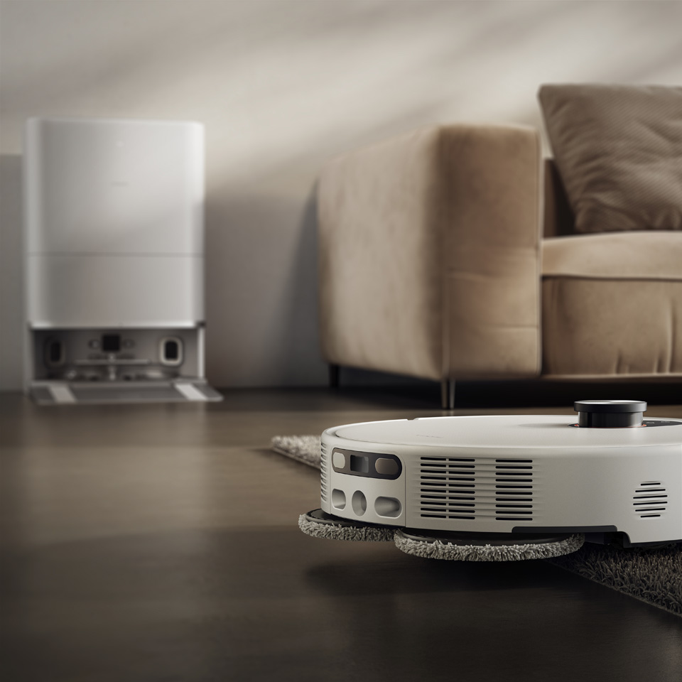 Xiaomi Robotstøvsuger 5 Pro kører fra et hårdt gulv op på et gråt tæppe.